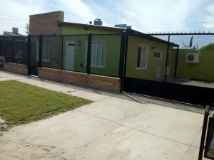 a fence next to a building with a green house at CASA BALCARCE in Balcarce