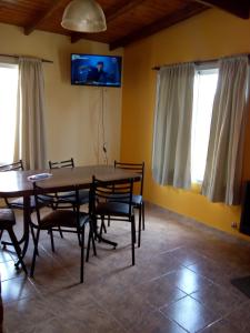 a dining room with a table and chairs and a tv at CASA BALCARCE in Balcarce