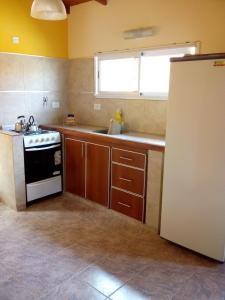 a kitchen with a stove and a sink and a refrigerator at CASA BALCARCE in Balcarce