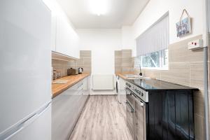 a kitchen with white cabinets and a black counter top at Fantastic Location - TV in Every Bedroom! in Swansea