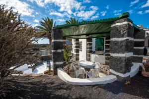 a stone house with a table and chairs outside at El Rincón in Masdache