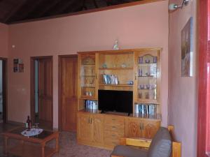 una sala de estar con un centro de entretenimiento de madera con TV en Casa Zaida, en San Sebastián de la Gomera