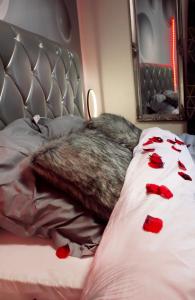 a dog laying on a bed with red roses on it at Wonderlove cocon (coeur de ville, cathédrale) in Nantes