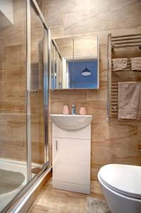 ein Badezimmer mit einem weißen Waschbecken und einer Dusche in der Unterkunft Roman Height's Holiday Cottages in Haltwhistle + 25 Fotos