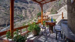 a balcony with a table and stools and a view at Casas rurales de Guayadeque in Ingenio