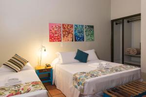 a room with two beds and a table at Hotel Porto Di Mare in Ubatuba +50 photos