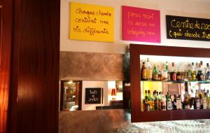 a bar with a bunch of bottles of alcohol at Le Windsor, Jungle Art Hotel in Nice