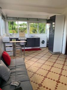 a kitchen with a couch and a table in a room at Soleil levant in Petit-Bourg