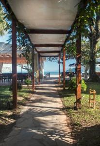 una pasarela bajo un pabellón en la playa en Hotel Porto Di Mare, en Ubatuba