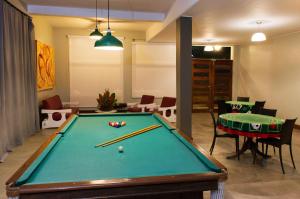 um quarto com uma mesa de bilhar e uma sala de jantar em Hotel Porto Di Mare em Ubatuba