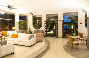 
a living room filled with furniture and a large window at Hotel Porto Di Mare in Ubatuba
