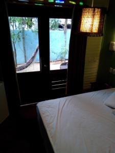 a bedroom with a bed and two windows with a view of a pool at Maria Teresa Bragança Pousada in Jericoacoara