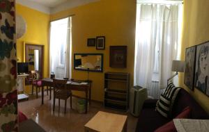 ローマにあるAppartamento del Boschettoの黄色の壁のリビングルーム(テーブル、椅子付)
