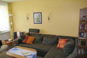 Fewo SH4 في جوسلار: غرفة معيشة مع أريكة رمادية مع وسائد برتقالية