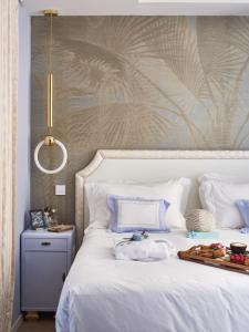 a white bed with a tray of food on it at Maison Panthère - Luxury Harbour Residence in Saint-Tropez