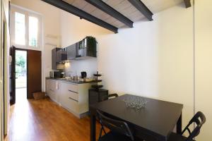 une cuisine avec une table et des chaises ainsi qu'une salle à manger dans l'établissement Paki Home nel cuore dei navigli di Milano, à Milan