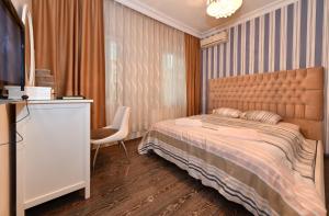sypialnia z łóżkiem, telewizorem i krzesłem w obiekcie İskete Suit w Stambule