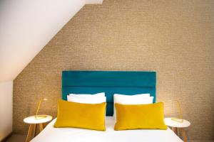 コパオニクにあるNeva Apartment Angella Konaciの黄色い枕が2つ付いたベッドのある寝室