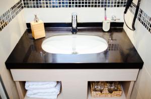 コパオニクにあるNeva Apartment Angella Konaciのバスルーム(ブラックカウンタートップ付きのシンク) +16枚の写真