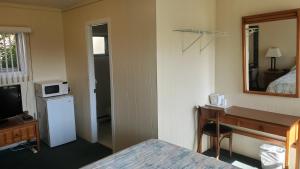 um quarto de hotel com uma cama, uma secretária e um espelho em Wasaga Beach Inn And Cottages em Wasaga Beach