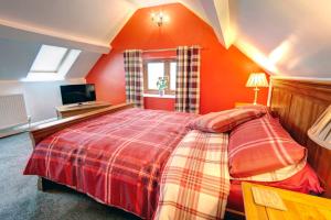 ein Schlafzimmer mit einem großen Bett mit orangefarbenen Wänden in der Unterkunft Roman Height's Holiday Cottages in Haltwhistle