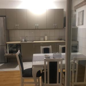 a kitchen with a table and chairs and a kitchen with white cabinets at Trebinje Mirjana in Trebinje