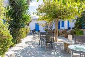 un patio avec des tables, des chaises et des arbres dans l'établissement Mykonos Vouniotis Rooms, à Mykonos