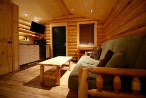 een woonkamer met een bank en een tafel in een hut bij Port Hardy Cabins in Port Hardy
