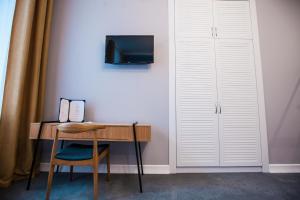 a desk with a chair and a television on a wall at E4 Hotel in Odesa