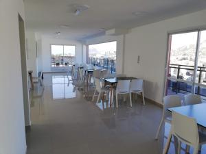 a dining room with tables and chairs and windows at DEPARTAMENTO Edificio LEONARDO in Villa Carlos Paz
