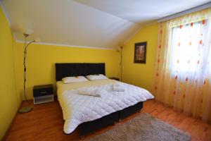 a bedroom with a bed and a yellow wall at Nana Tekija in Tekija