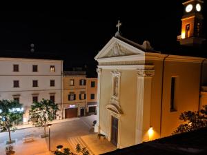 a building with a clock tower at night at Piazza Duomo Deluxe in Cecina