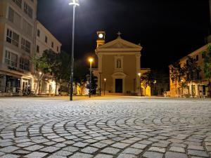 a cobblestone street in front of a building at night at Piazza Duomo Deluxe in Cecina