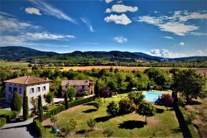 an aerial view of a house and a swimming pool at Borgo Il Villino in Casole dʼElsa