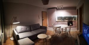salon z kanapą i stołem w obiekcie Zielona Krynica Apartament w mieście Krynica Morska