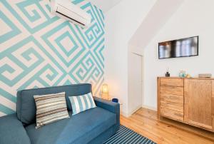 a living room with a blue couch and a wall at Casa do Sapalinho II - Setubal Downtown in Setúbal +8 photos