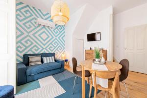 a living room with a table and a blue couch at Casa do Sapalinho II - Setubal Downtown in Setúbal