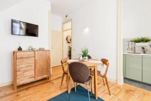 a dining room with a wooden table and chairs at Casa do Sapalinho II - Setubal Downtown in Setúbal