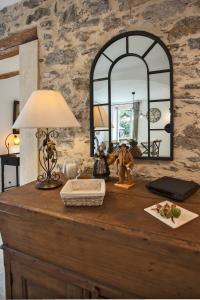 ein Tisch mit einer Lampe und einem Spiegel darauf in der Unterkunft LA SOURCE 4 chambres in Valle d'Alesani