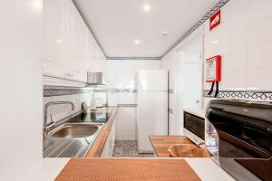 a white kitchen with a sink and a refrigerator at Casa Bela Vista in Sesimbra