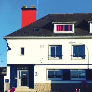 a white building with a red chimney and two windows at Les Abeilles in Saint-Nazaire