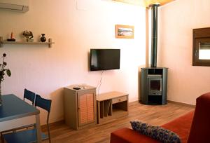 a living room with a tv and a stove at El Retiro de Ceubia by RetiroRural in Arenas de San Pedro