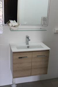 a bathroom with a sink and a mirror at Acacia Motor Inn in Armidale