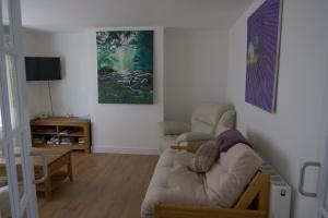 a living room with a couch and a table at Kirkside Holiday Home in Alness