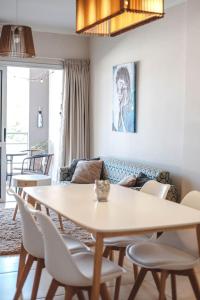 a living room with a table and chairs at Departamento amplio, nuevo y céntrico in Posadas
