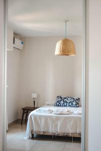 een witte slaapkamer met een bed en een spiegel bij Departamento amplio, nuevo y céntrico in Posadas