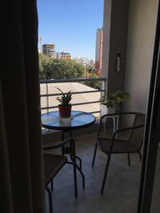 a small table and chairs on a balcony with a view at Departamento amplio, nuevo y céntrico in Posadas