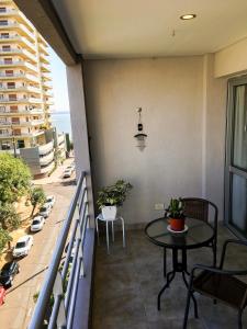 a balcony with a table and potted plants on it at Departamento amplio, nuevo y céntrico in Posadas