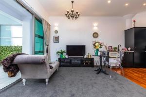 a living room with a couch and a television at *Vibrant Viaduct Harbour Apartment with Balcony & Best Location* Auckland in Auckland