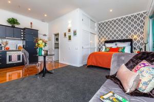 a living room with a bed and a kitchen at *Vibrant Viaduct Harbour Apartment with Balcony & Best Location* Auckland in Auckland